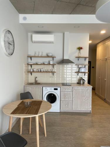 a kitchen with a table and a washing machine at Sweet home30 in Vilnius