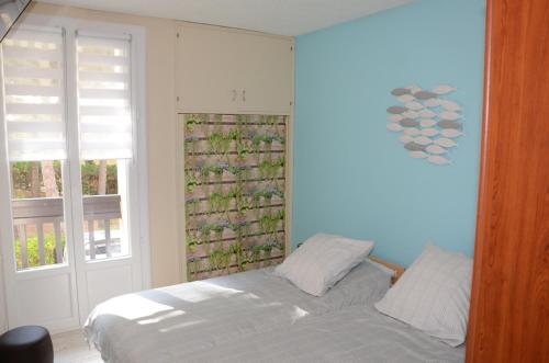 une chambre avec un lit et deux fenêtres dans l'établissement T2 au calme avec clim 100 m plage, classé 2 étoiles, à Argelès-sur-Mer