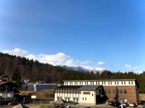 un grand bâtiment avec une montagne en arrière-plan dans l'établissement Snowdrop Apartment, à Sinaia