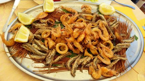 a plate of food with shrimp and lemon slices at Hotel Castiglione in Ischia