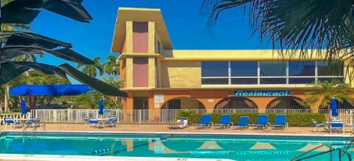 a resort with a swimming pool in front of a building at Bposhtels Hollywood Florida in Hollywood