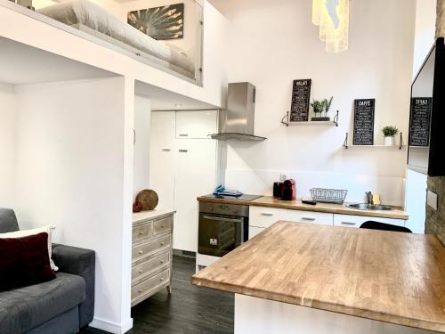 a kitchen with a table and a couch in a room at Studio Mezzanine Rue Pieta in Menton
