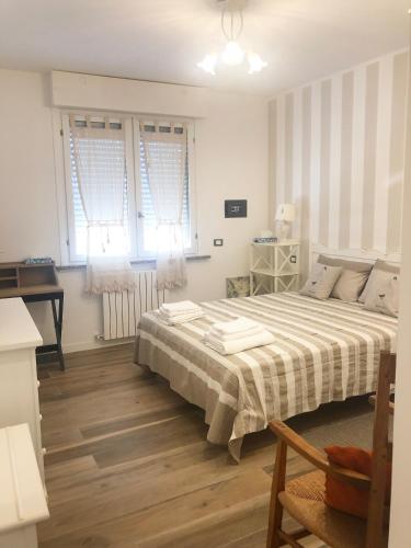 1 dormitorio con 1 cama grande y 2 ventanas en La Rosa Bianca, en Rozzano