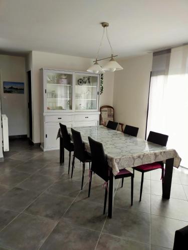 une salle à manger avec une grande table et des chaises en marbre dans l'établissement Le clos du bois, à Erdeven