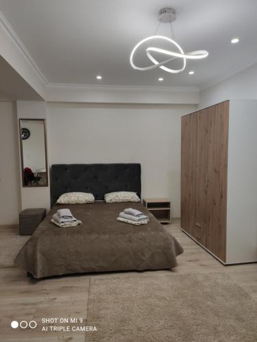 1 dormitorio con 1 cama grande y techo blanco en Apartments Domovik Korzo, en Mukácheve