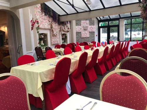 een vergaderzaal met een lange tafel en rode stoelen bij Kensington Hotel in Bournemouth