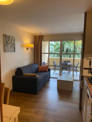 a living room with a blue couch and a table at Studio Cap Esterel in Agay - Saint Raphael