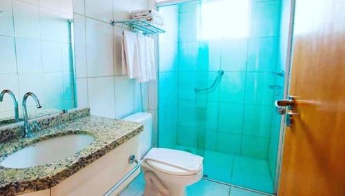 un bagno con wc, lavandino e doccia di Hotel Golden Dolphin com café da manhã! Piscinas 24h a Caldas Novas