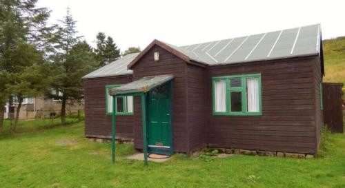 a small house with a green door in a field at Scotland Shooting Club in Balintore