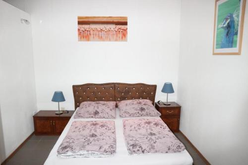 sypialnia z łóżkiem z 2 stolikami nocnymi i 2 lampami w obiekcie Holiday Home Roy w Berlinie