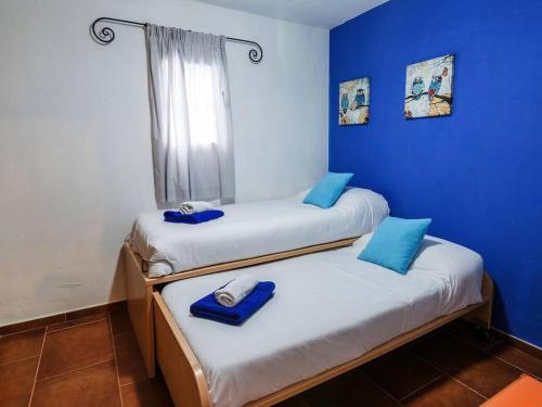 2 camas en una habitación con paredes azules en LEIDA - Relax y privacidad, en Cala Blanca