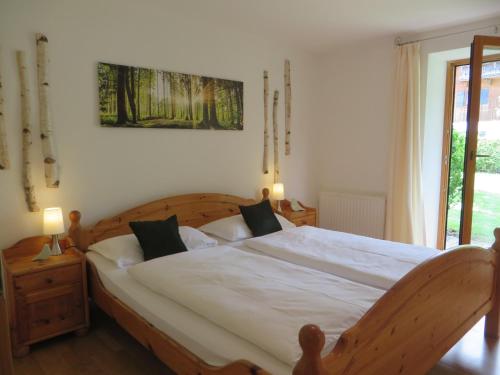 a bedroom with a large bed with white sheets at Landhaus Familie Doll Ferienwohnung Emerde in Bichl