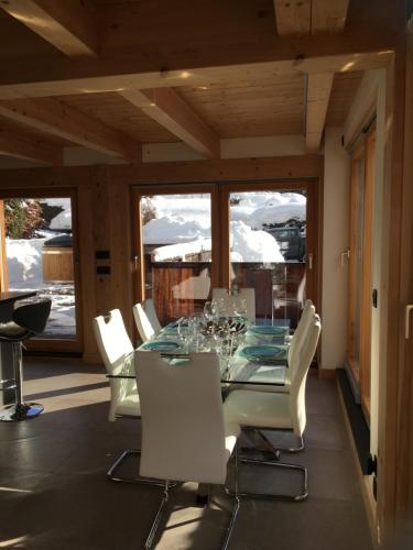 シャモニー・モンブランにあるChalet Plan Glacierのテーブルと白い椅子のあるダイニングルーム