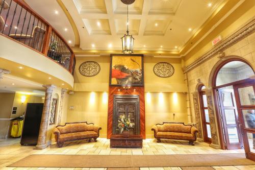 a lobby with two chairs and a painting on the wall at Hotel Brossard in Brossard