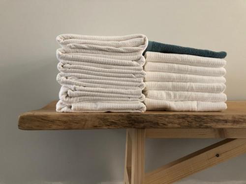 a stack of towels sitting on a wooden table at Margareta Stay in Mechelen