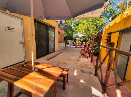 a wooden bench sitting on a patio under an umbrella at CASA LILI LUXURY VALLADOLID "Fast Wifi, Hot Water, Kitchen & TV" in Valladolid
