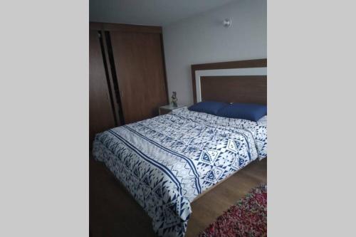 um quarto com uma cama com uma colcha azul e branca em Tu mejor decisión a 20 minutos de Bogotá. em Mosquera