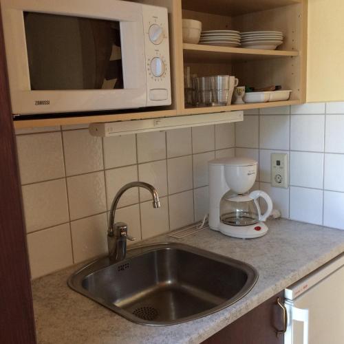 a kitchen counter with a sink and a microwave at Munkamöllan B&B Skåne Tranås in Skåne-Tranås