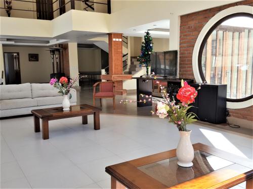 a living room with a couch and a table with flowers at Casa Tabolango , Limache in Limache