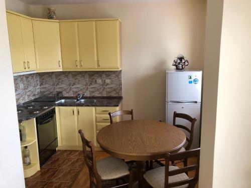 a kitchen with a table and a white refrigerator at Apartman Djina in Vrnjačka Banja