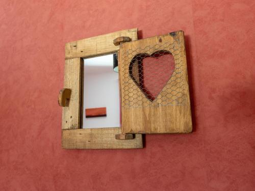 a mirror with a heart on a red wall at Sunny Roquebrun Getaway in Roquebrun