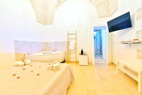una camera da letto con vasca e un letto con asciugamani di Trullo Suite a Cisternino