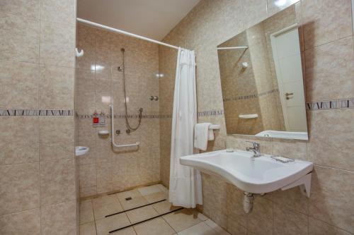 een badkamer met een wastafel en een douche bij Huemul in Neuquén