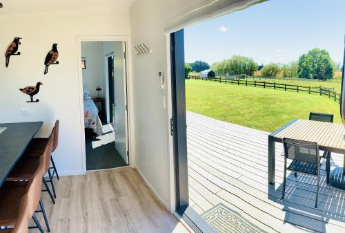 a deck with a table and a view of a field at Heaven's Rest B&B in Pukekohe East