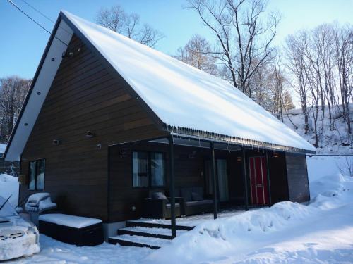um pequeno edifício com um telhado coberto de neve em ZEN CHALETS Hakuba em Hakuba