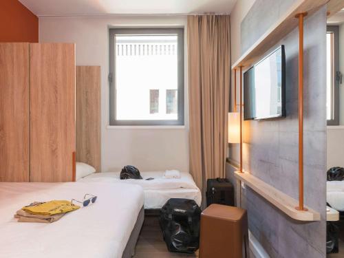 um quarto de hotel com duas camas e uma televisão em ibis budget Gent Centrum Dampoort em Gent