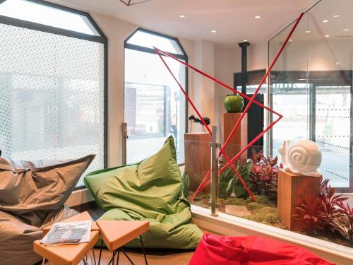 a living room with a couch and some windows at ibis Styles Nantes Centre Gare in Nantes