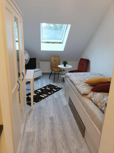 Schlafzimmer mit einem Bett, einem Tisch und einem Fenster in der Unterkunft BK City Apartments in Backnang