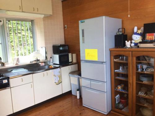eine Küche mit Kühlschrank und Spüle in der Unterkunft GantanBunny in Motobu