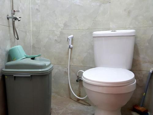 a bathroom with a toilet and a trash can at EDUTAMA Homestay Syariah in Kediri