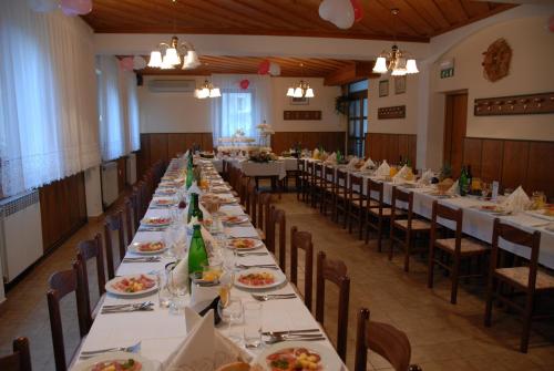 a long dining room with long tables and chairs at Guesthouse Pri Štefanu in Most na Soči