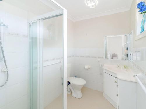un bagno bianco con doccia e WC di Shellcot a Yamba
