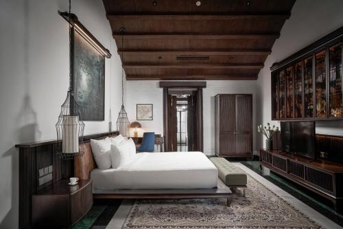 a bedroom with a bed and a couch and a tv at The Secret Con Dao in Con Dao