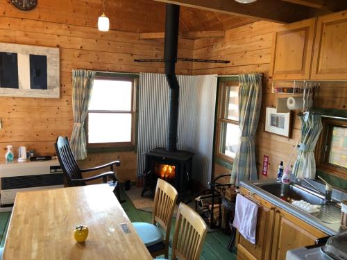 a kitchen with a stove and a table in a room at 南房総 貸切コテージ セントシュバイン in Minamiboso
