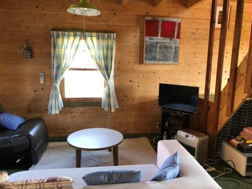 a living room with a couch and a window at 南房総 貸切コテージ セントシュバイン in Minamiboso