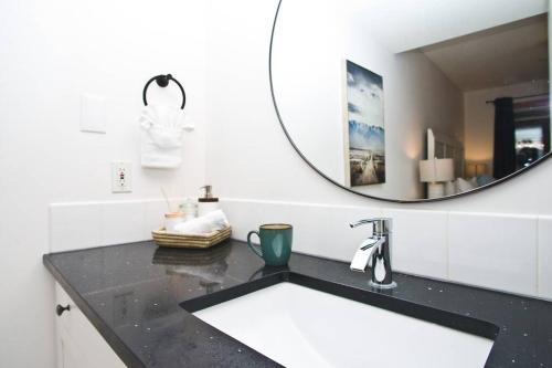 a bathroom with a sink and a mirror at Pinnacle Mountain View Condo 3 Bed 2 Bath Downtown Canmore in Canmore