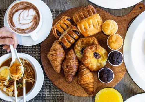 una mesa con un plato de bollería y una taza de café en Holiday Inn Singapore Atrium, an IHG Hotel en Singapur