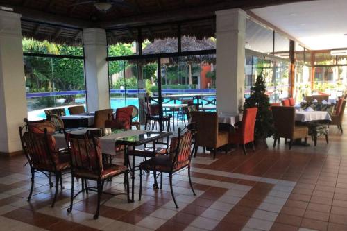 a restaurant with tables and chairs and a pool at Departamento en Condominio Buganvillas in Santa Cruz de la Sierra