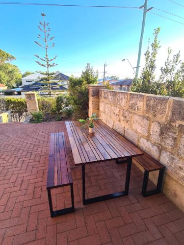 a wooden picnic table sitting on a brick patio at Sunset views over South Fremantle in Fremantle