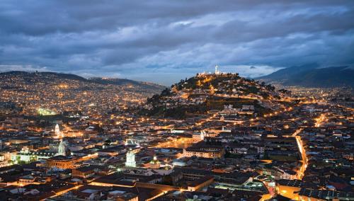 a view of a city at night with a mountain at Mercure Alameda Quito in Quito