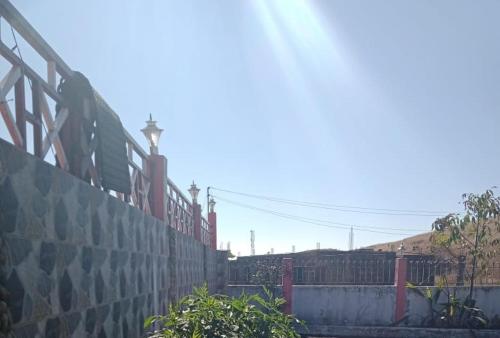 a fence next to a wall next to a building at Sulawado Resort in Cherrapunji