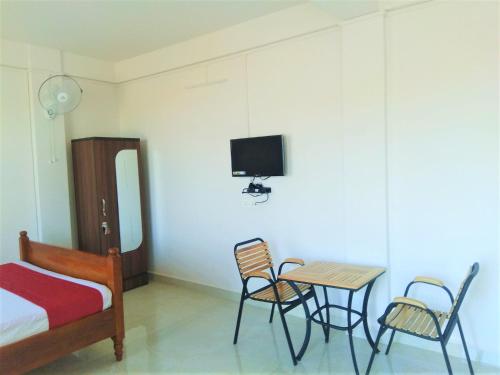 a bedroom with a bed and a table and chairs at Sulawado Resort in Cherrapunji