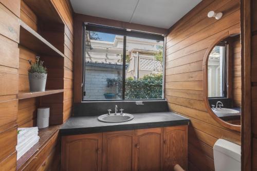 a bathroom with a sink and a window at Manly Waves Studios & Apartments in Sydney