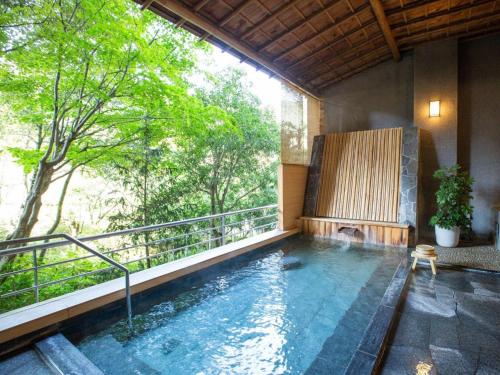 a swimming pool in a house with a balcony at Yamagataya in Gero