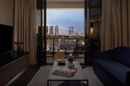 a living room with a blue couch and a view of a city at Hotel X Brisbane Fortitude Vly, Vignette Collection by IHG in Brisbane