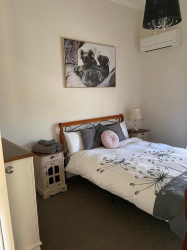 ein Schlafzimmer mit einem Bett und einem Bild an der Wand in der Unterkunft Yea River Cottage in Yea